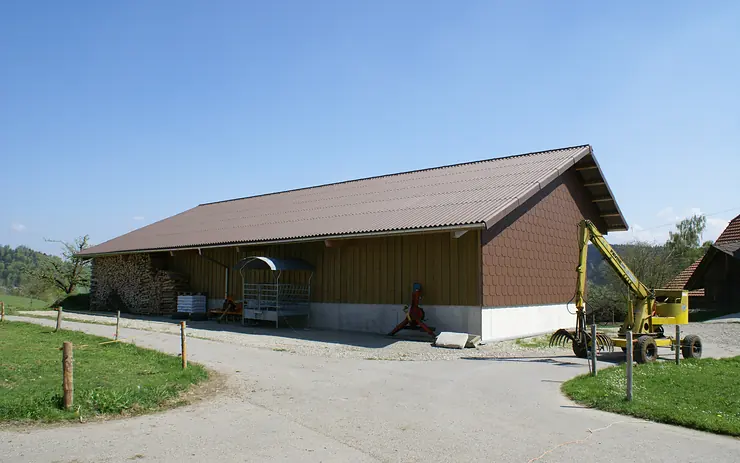 Landwirtschaftsgebäude mit Blechdach und schuppenförmig verlegter Blechverkleidung am Giebel
