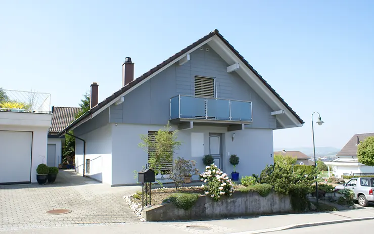 Einfamilienhaus mit steilem Ziegeldach, weitem Dachüberstand und Balkon – Steildach-Arbeit von Sterchi Bedachungen