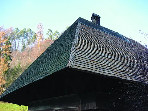 Nahaufnahme eines Holzschindeldachs: sauber ausgerichtete Schindellagen am Ortgang eines Emmentaler Bauernhauses