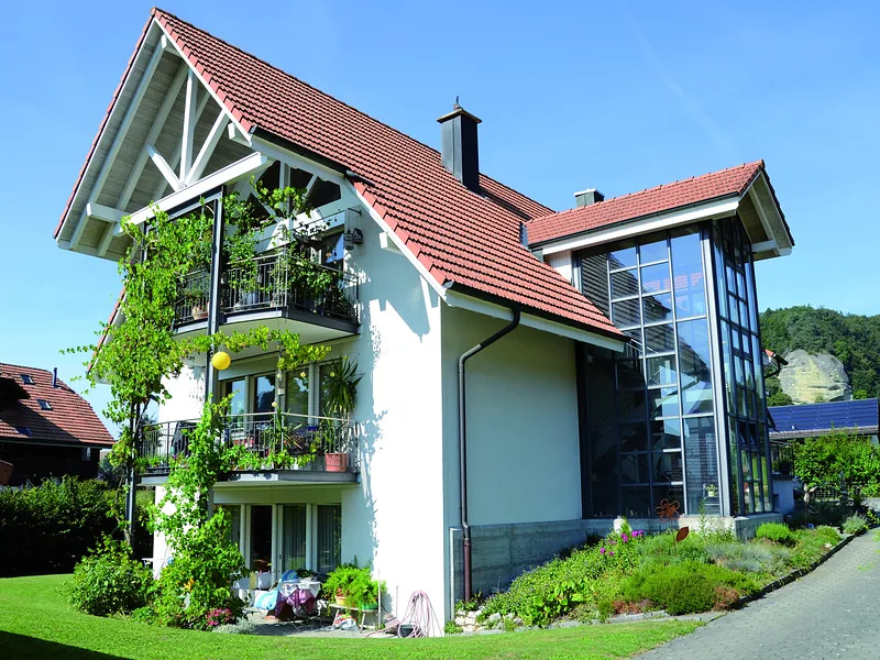 Einfamilienhaus mit rotem Ziegeldach und verglastem Giebel